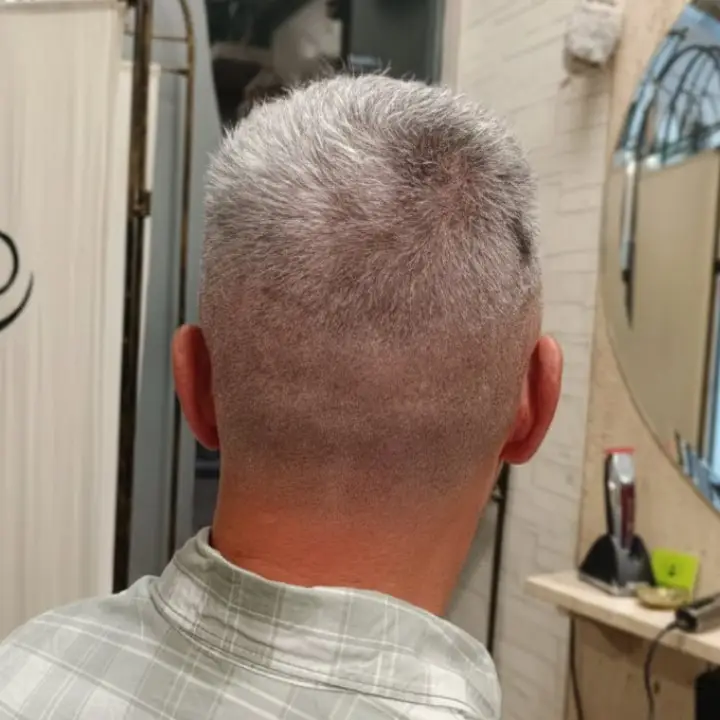 Corte corto de caballero con cabello canoso visto desde la nuca